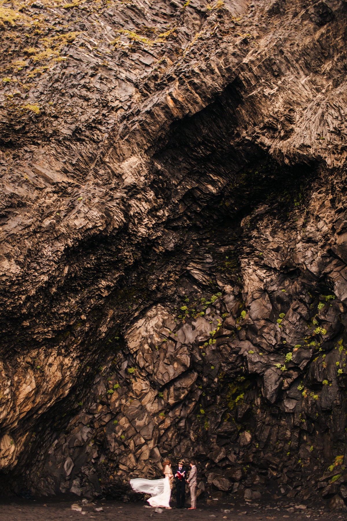 Iceland elopement photographer — couple in a towering basalt sea cave