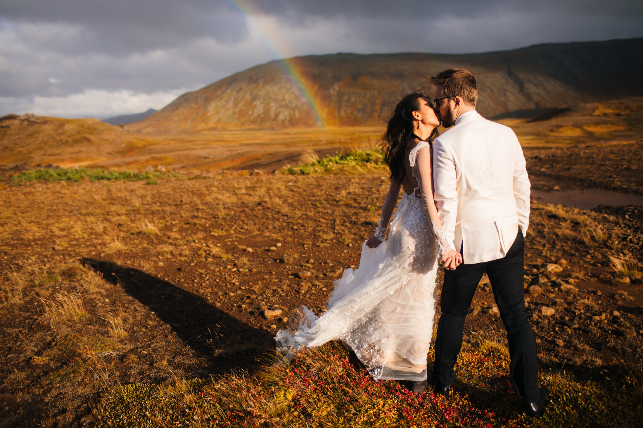 Iceland elopement photographer — couple kissing under a rainbow in the highlands